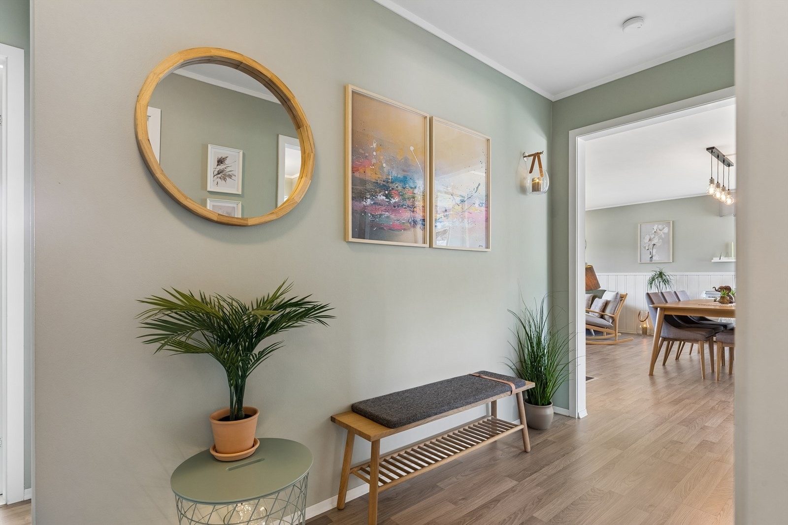 Pent laminatgulv og malte flater i delikate, lyse fargetoner gir et helhetlig inntrykk fra entréen og videre inn i boligen. Galleribilde