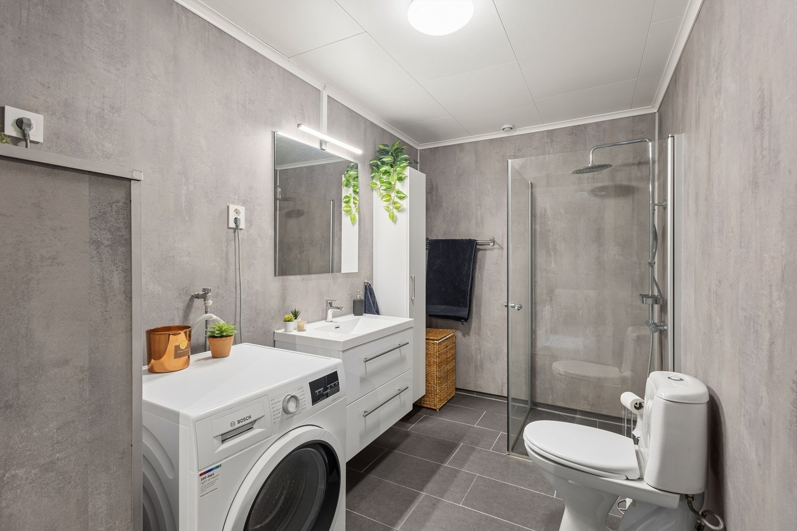 Baderomsinnredningen har hvite, glatte fronter med romslige skuffer og heldekkende servant. Over innredningen er det speil med tilhørende belysning. Galleribilde