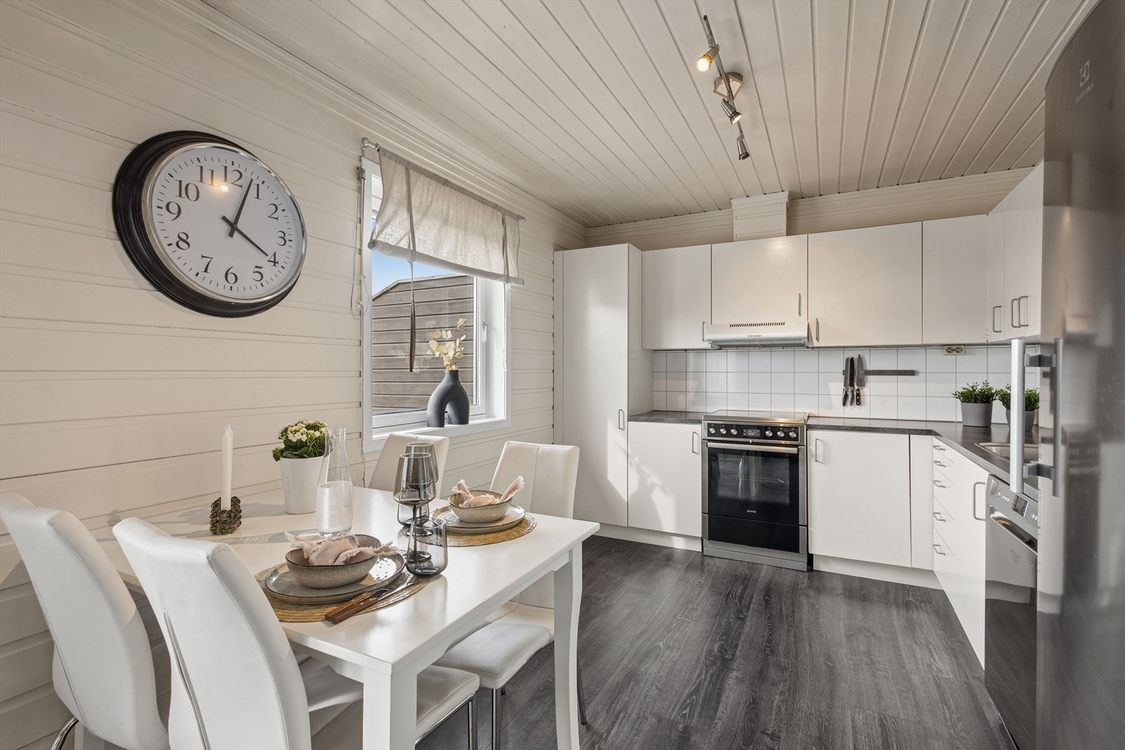 Kjøkkenet har en pen innredning med lyse, glatte fronter og laminert benkeplate med nedfelt kjøkkenkum. Galleribilde