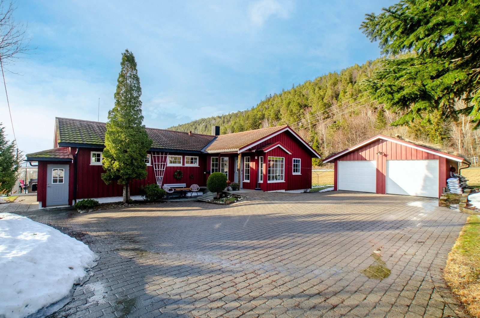 Romslig gårdsplass med belegningsstein og god plass til parkering. Galleribilde