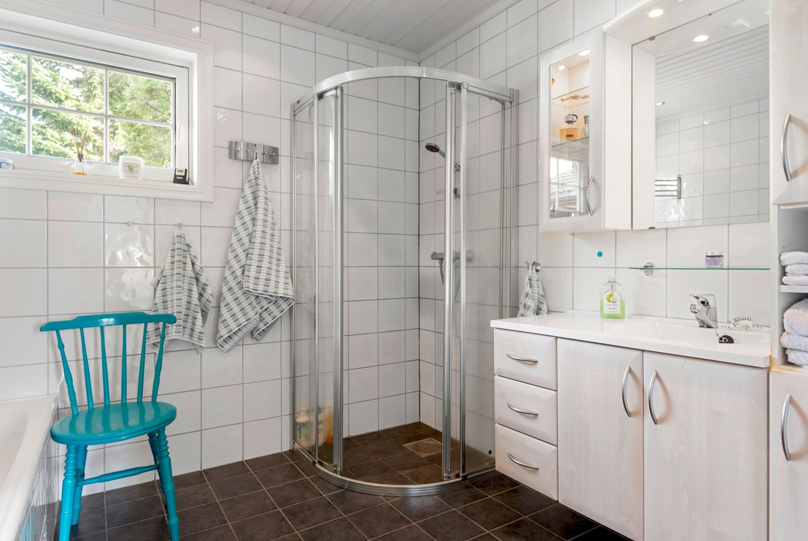 Flott, flislagt bad med varme i gulv, dusjhjørne, servantinnredning, toalett og badekar. Galleribilde