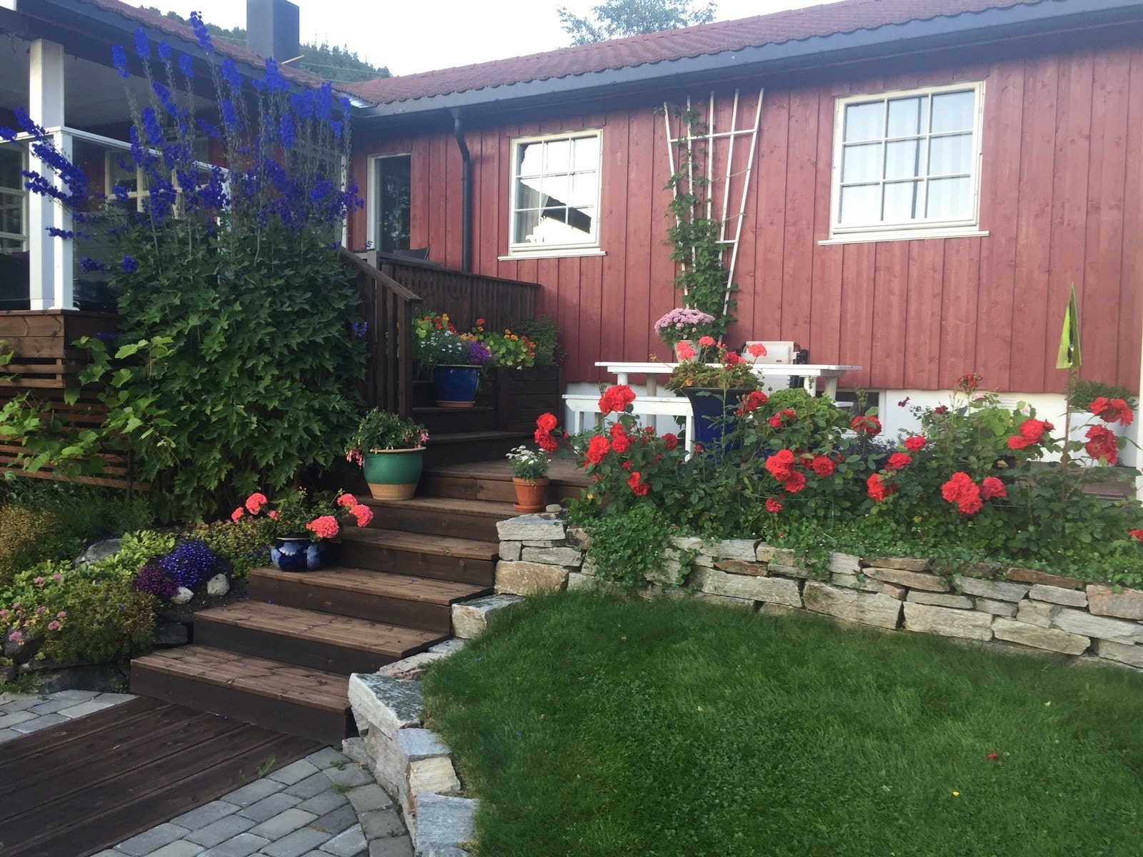 Hyggelig hageparti med velstelte blomsterbed og lun stemning Galleribilde