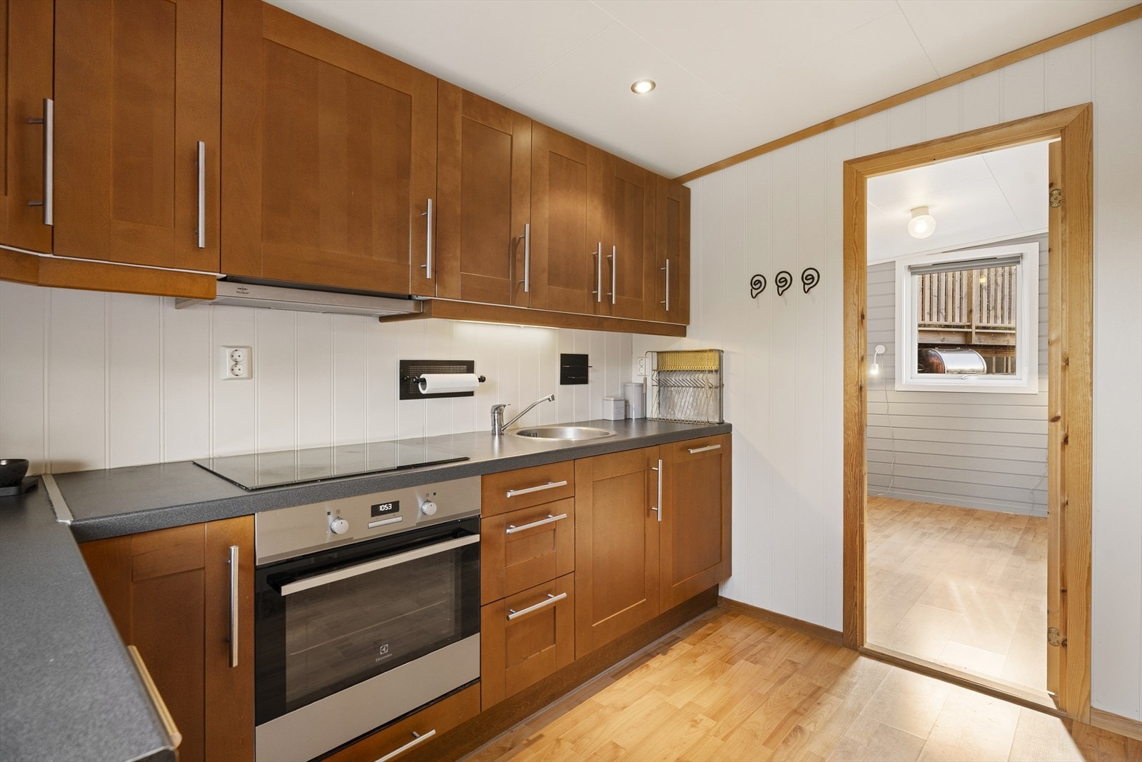 Kjøkkenet har innredning med profilerte fronter og laminat benkeplate Galleribilde