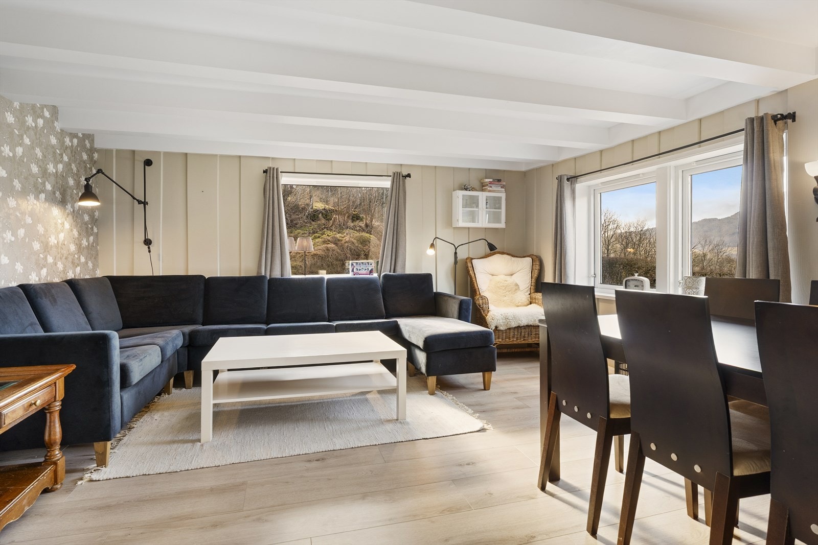 Fritidsboligen har en lys og pen stue med god plass til både sofagruppe og spisebord Galleribilde