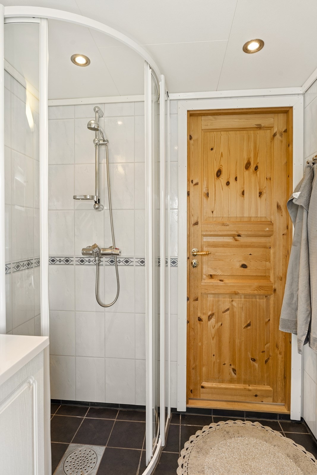 Badet er innredet med hvit baderomsinnredning, dusjdører og komposttoalett (Superdassen) Galleribilde