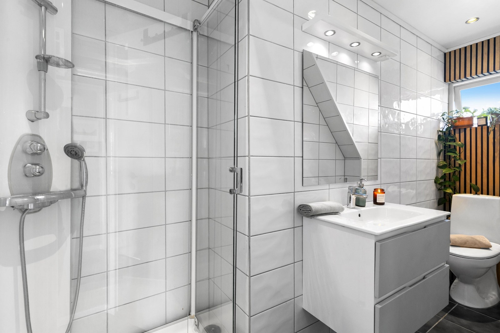 Innredningen består av en vegghengt servant med skuffer og spiler ved toalettet som en moderne detalj. Galleribilde