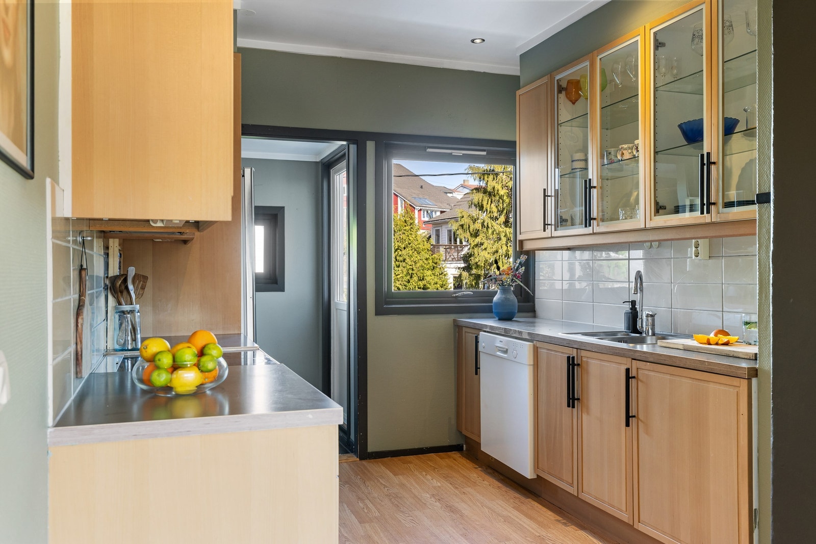 Kjøkkeninnredningen inkluderer integrert oppvaskmaskin, og det er fliser mellom benk og overskap. Galleribilde