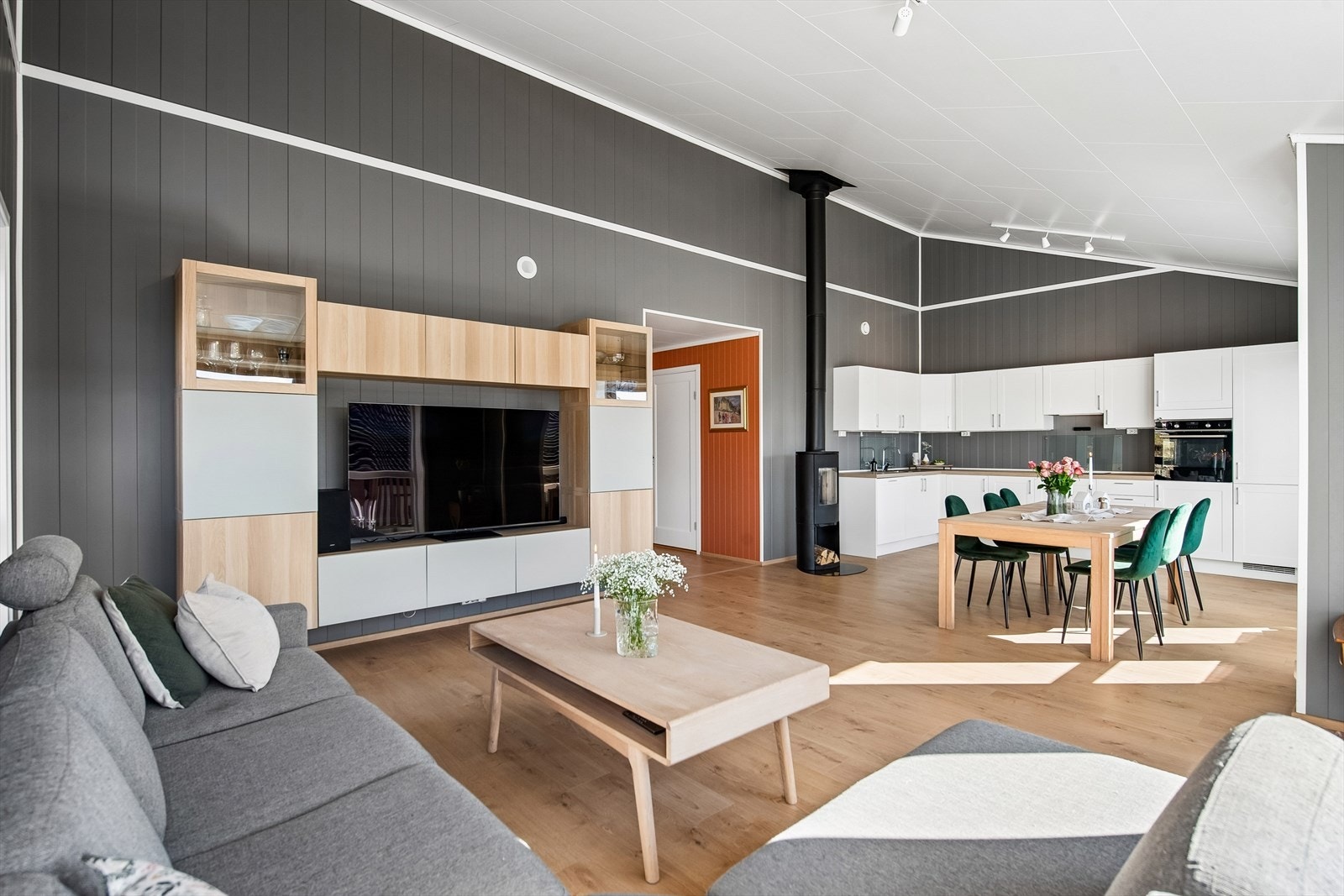 Moderne stue med gjennomtenkte løsninger og en behagelig atmosfære. Stue og kjøkken imponerer med ekstra takhøyde og elegant skråtak som skaper både særpreg og en romslig følelse. Galleribilde