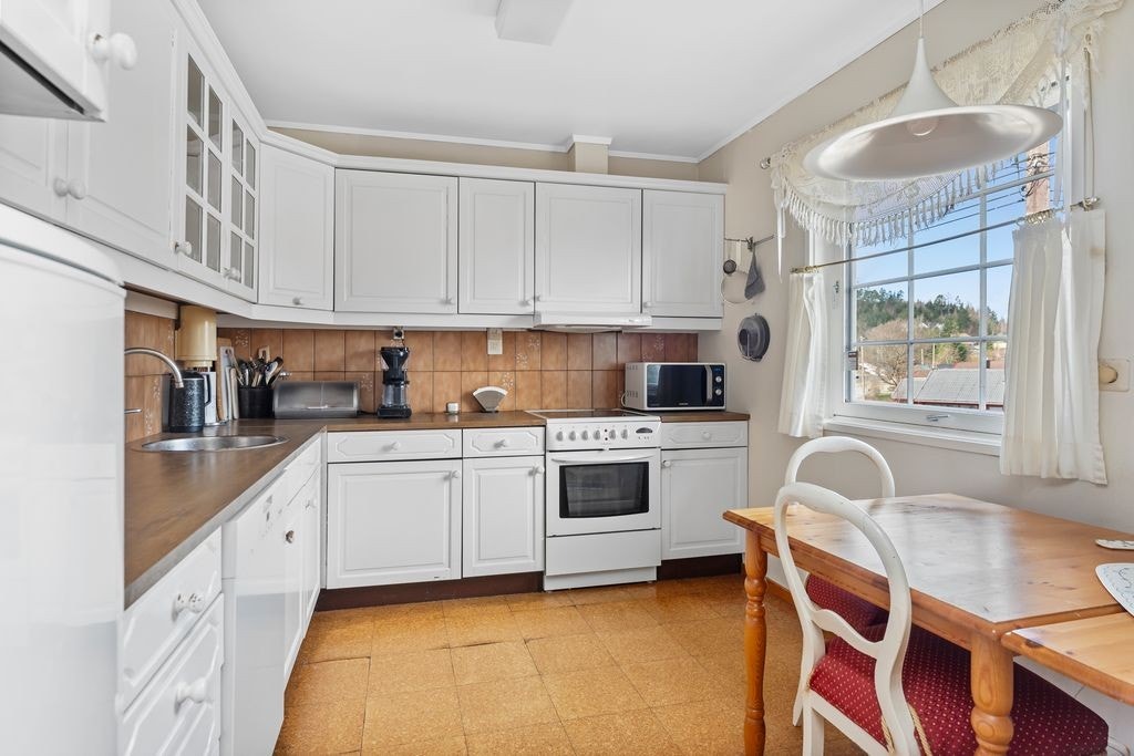 Kjøkken med profilert innredning og laminert benkeplate med nedfelt vask Galleribilde