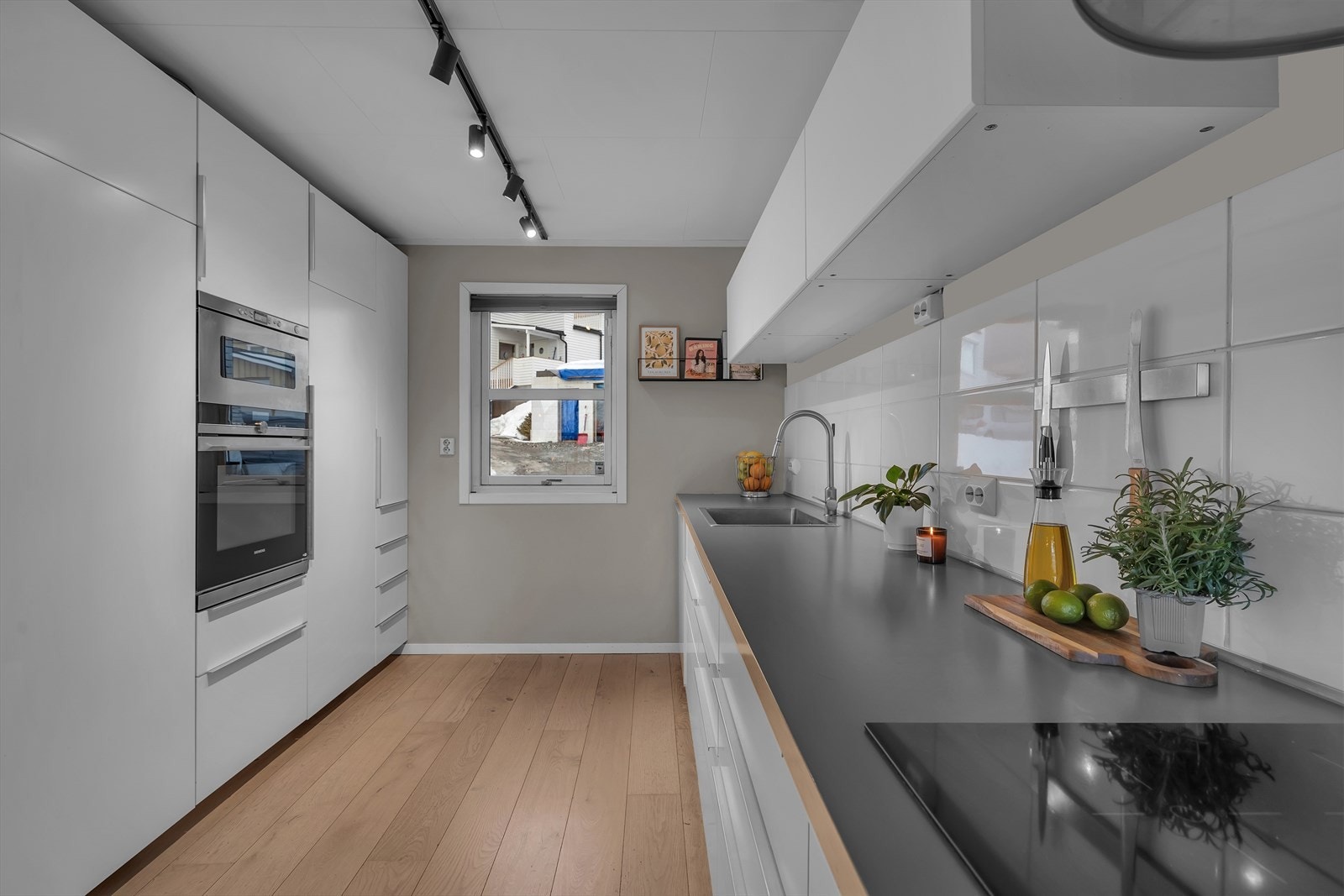 Lyst og innbydende kjøkken med helintegrerte hvitevarer Galleribilde