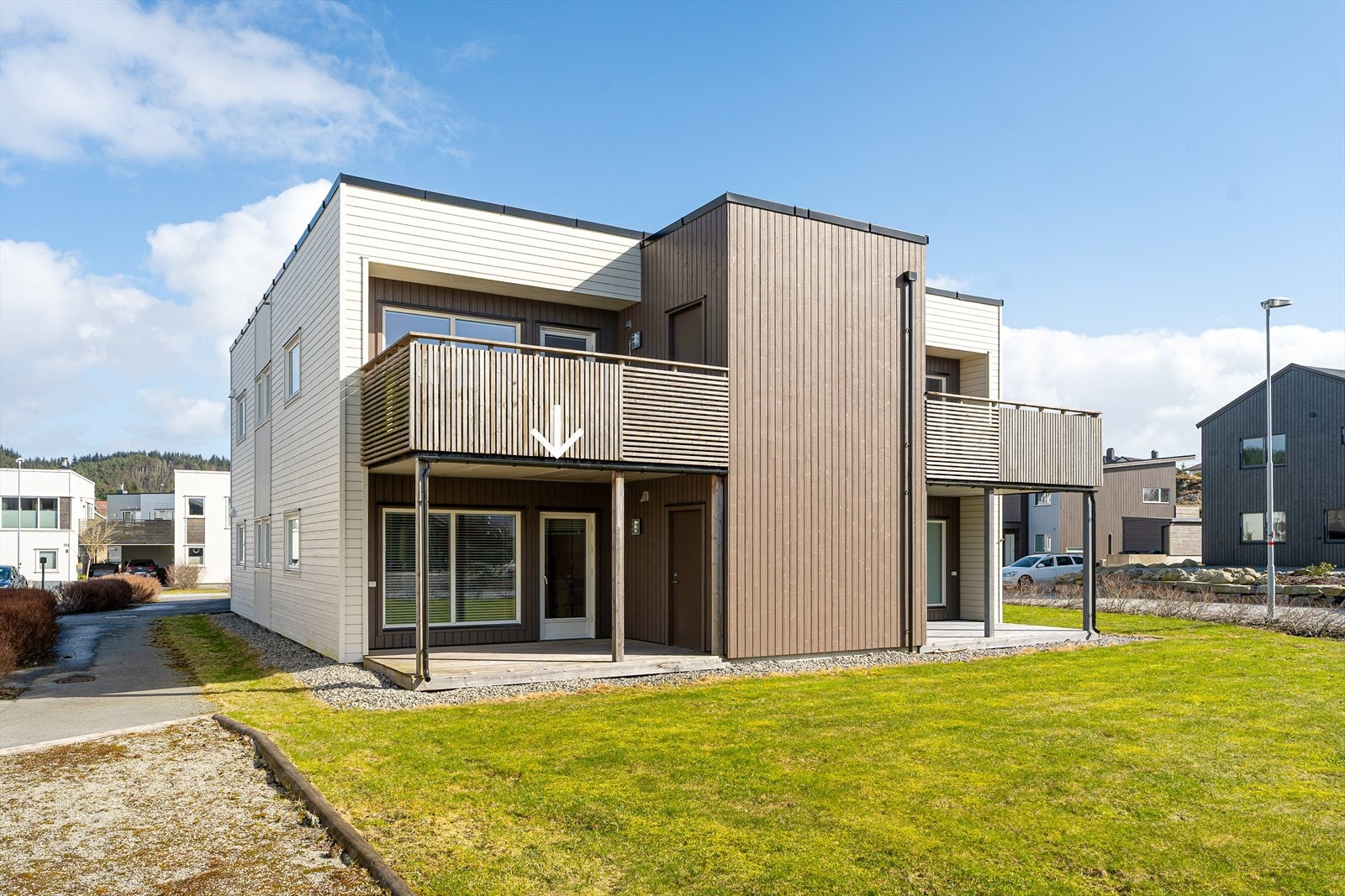 Flott opparbeidet fellesareal med gressplen, hekk og asfaltert gårdsrom Galleribilde