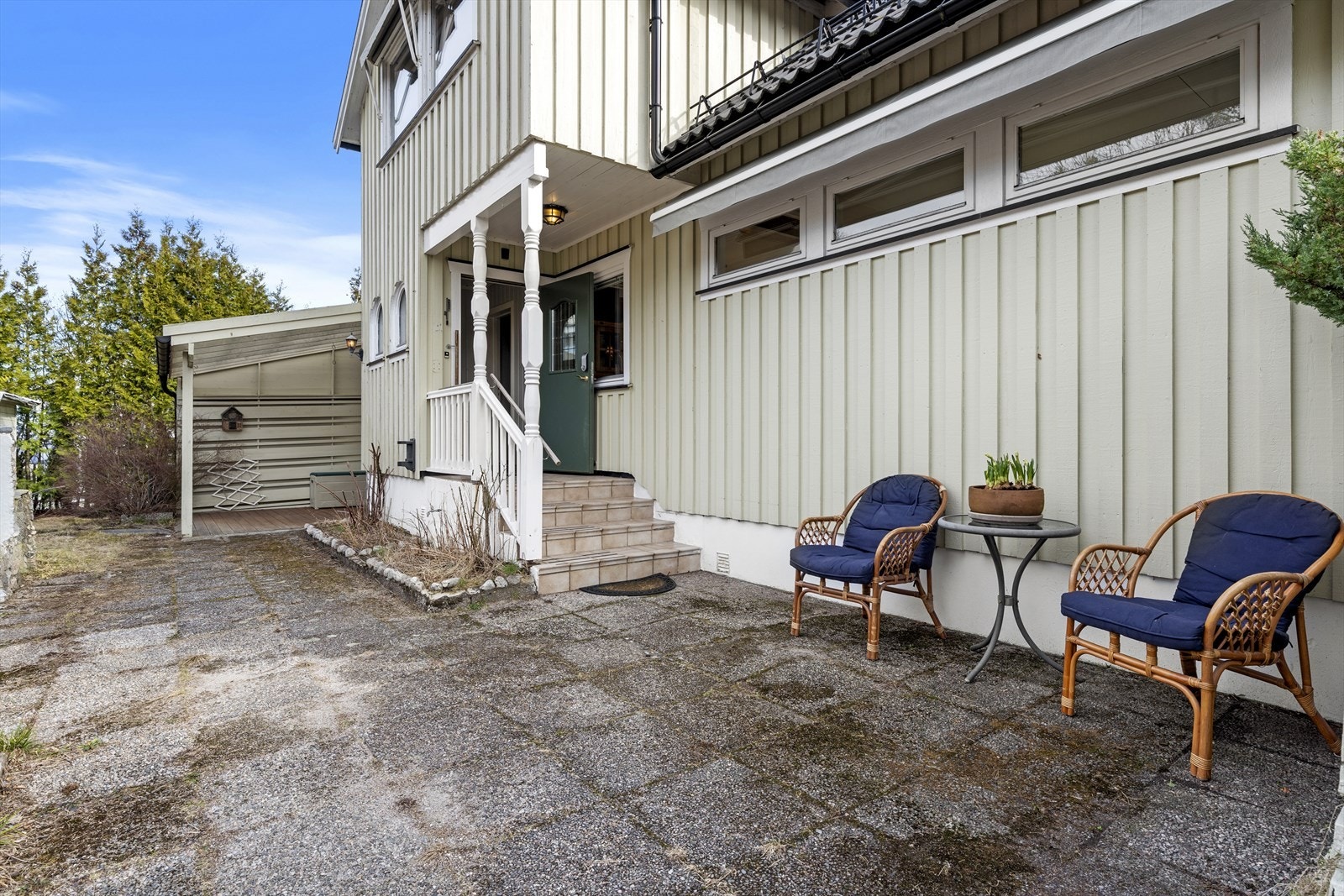 Inngangsparti med flere uteplasser, markise og adkomst til underetasje bak overbygget terrasse Galleribilde