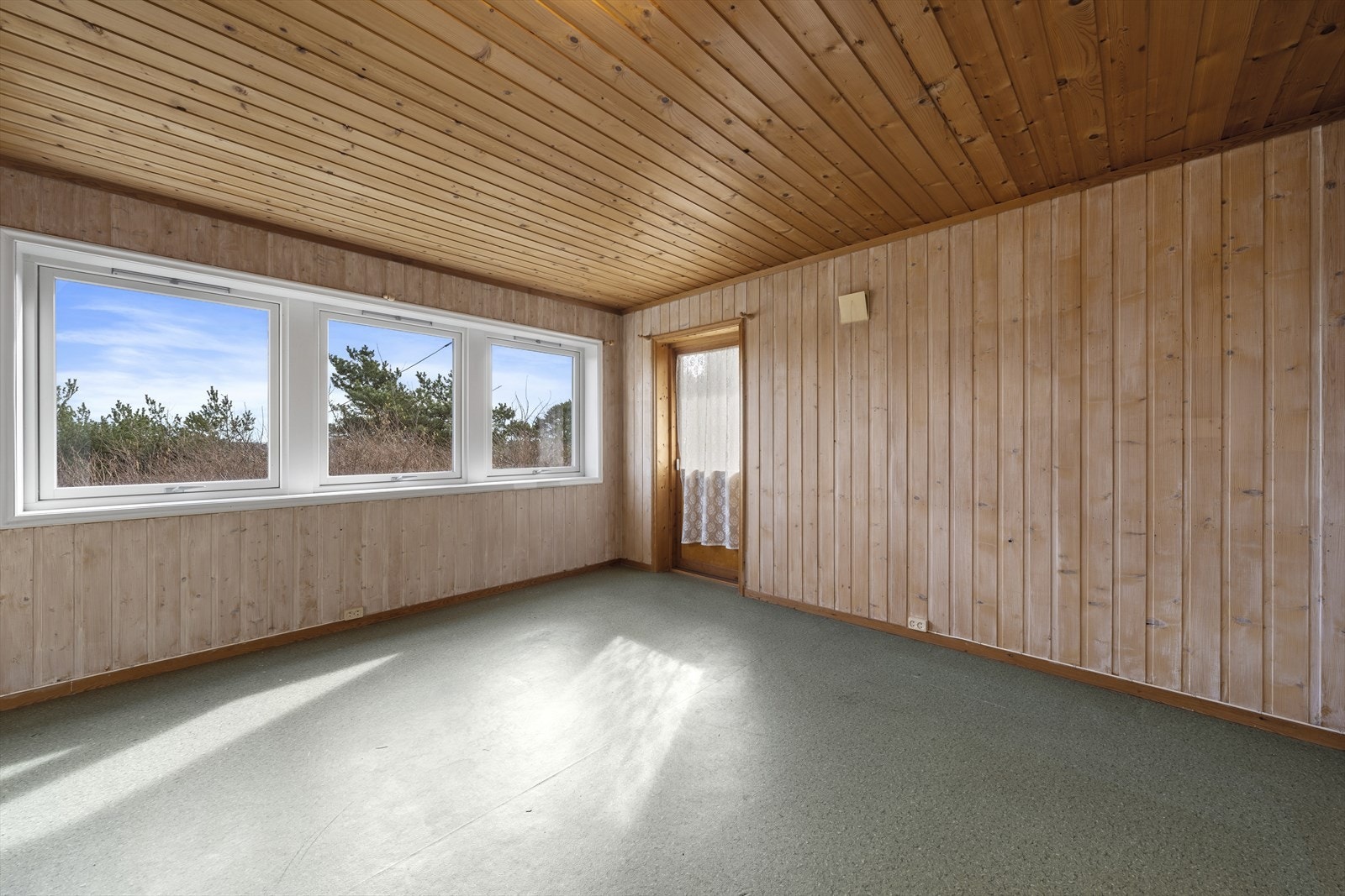 Det første rommet har store vinduer og verandadør ut til hage mot sør, mens det innerste rommet har mindre vindu og oppfyller ikke krav til varig opphold. Galleribilde