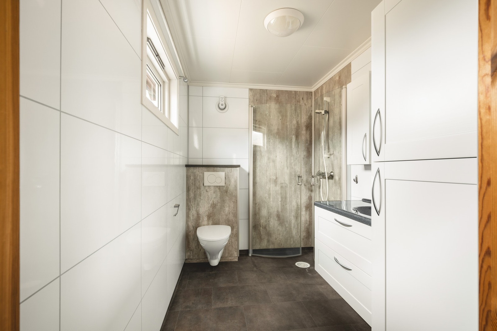 Delikat bad med våtromsplater på vegg og vinylbelegg på gulv med varmekabler. Galleribilde