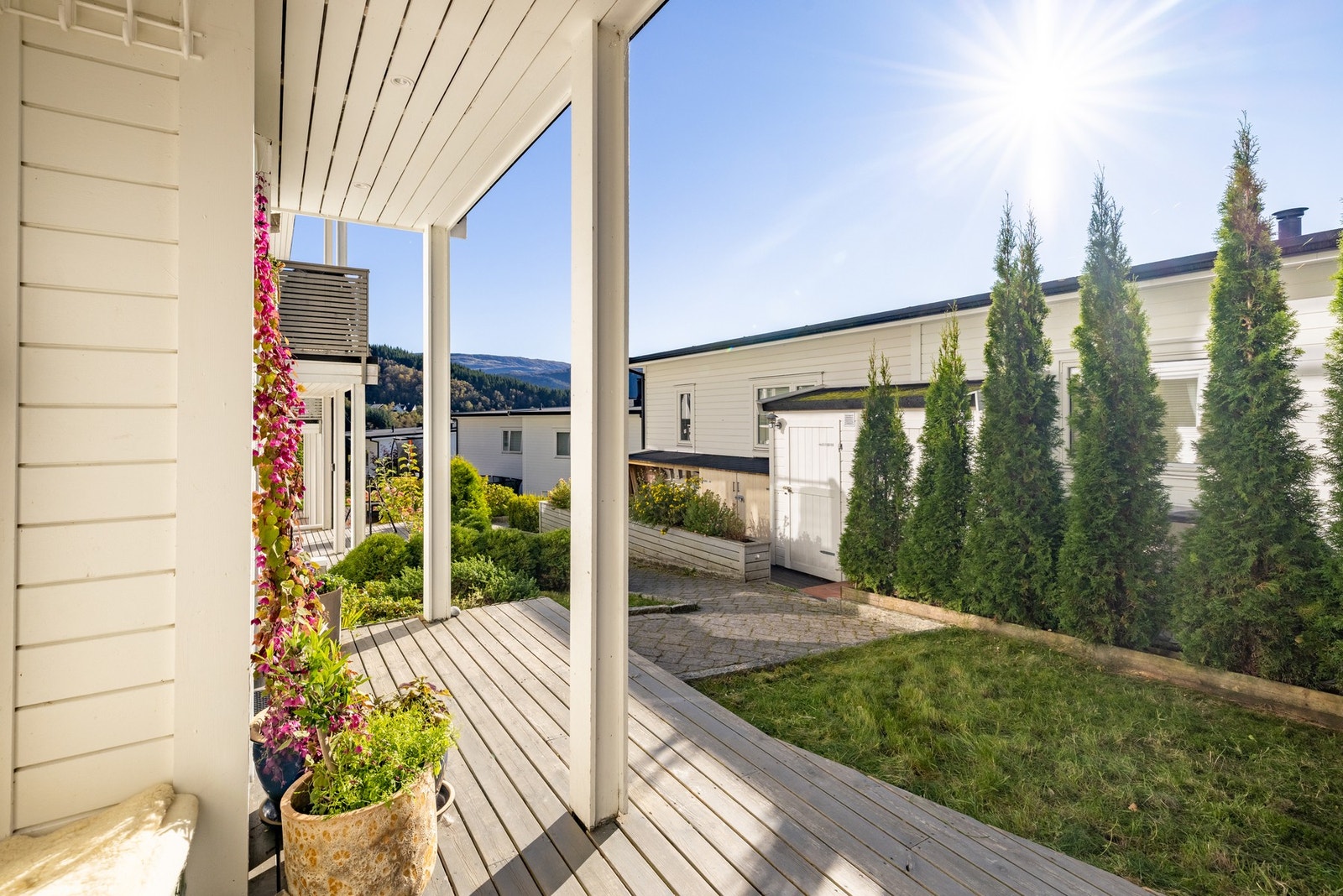 Inngangspartiet er pent opparbeidet med terrasse, belegningsstein, plen og hekk. Galleribilde