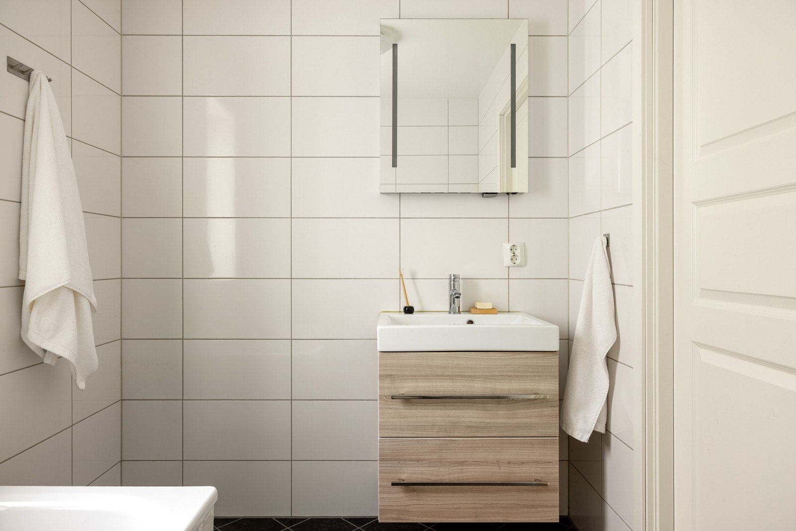 Det er innredet med vegghengt toalett, badekar med dusj og baderomsmøblement med speil og belysning. Galleribilde