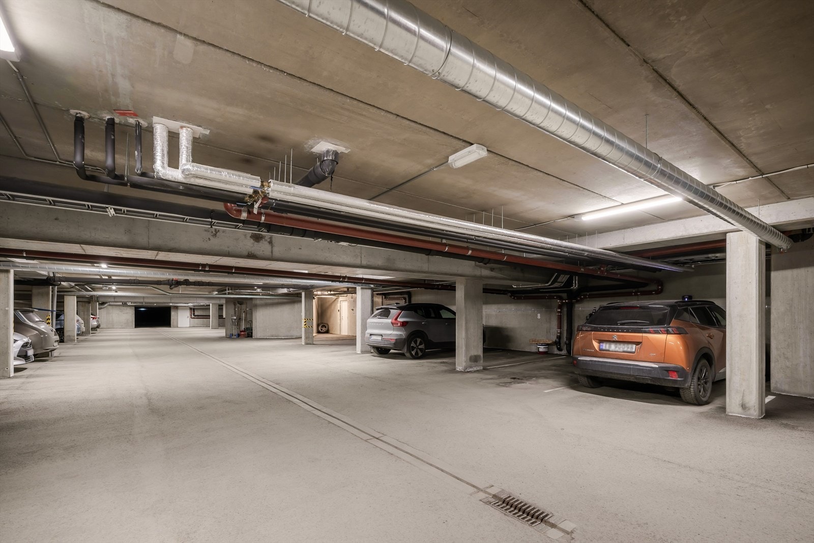 Det medfølger fast plass med ladepunkt i p-kjeller. I p-kjeller er det også rikelig med plasser forbeholdt parkering for gjester. Galleribilde