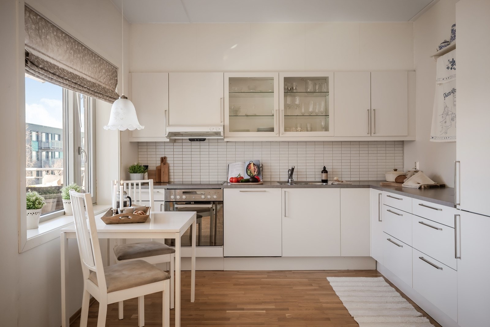 Kjøkkenet har godt med skap- og benkeplass i tidløs innredning i hvit utførelse bestående av underskap, skuffer og veggskap. Galleribilde