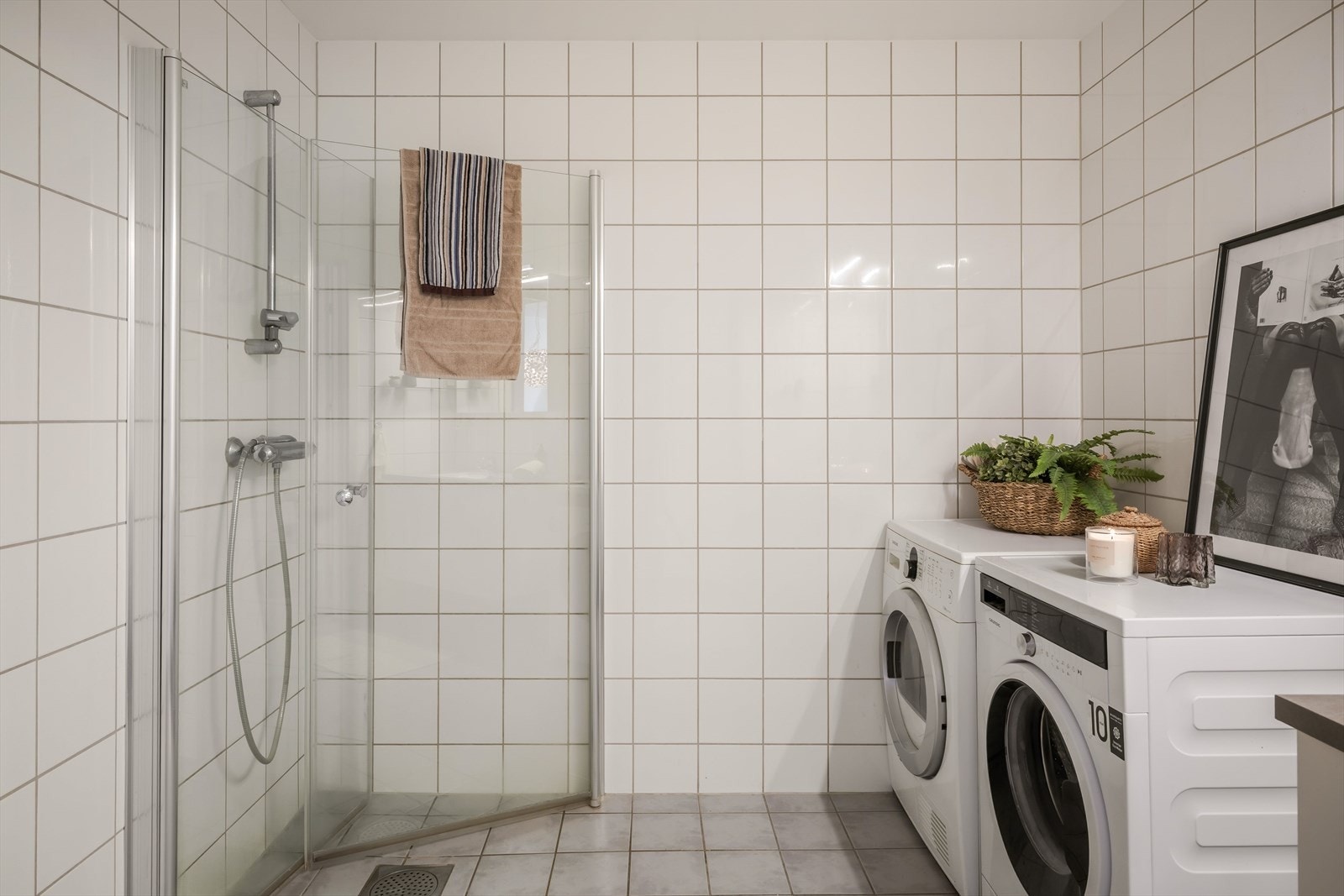 Baderommet er forøvrig innredet med dusjhjørne med innfellbare glassvegger, og opplegg for vaskemaskin Galleribilde