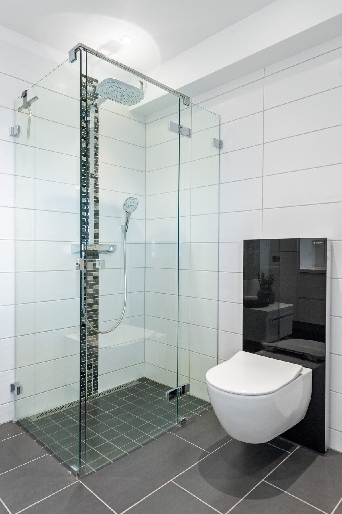 Baderomsinnredning med dobbel servant, veggehengt toalett og dusj med glassvegger. Galleribilde