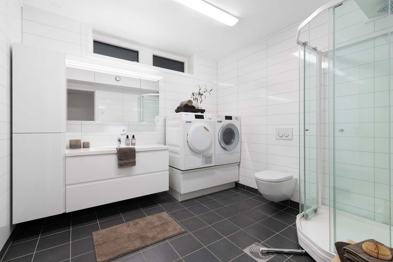 Bad/vaskerom med flislagt gulv med vannbåren gulvvarme og elektriske varmekabler. Galleribilde