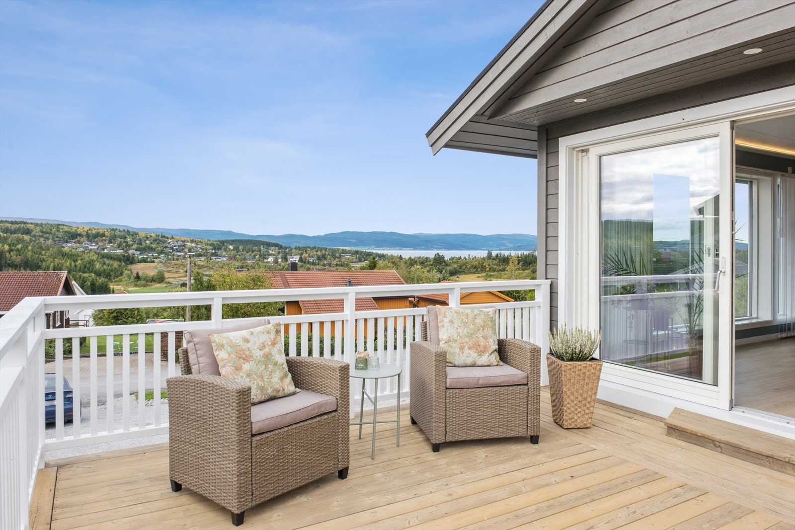 Stor skyvedør fra stue fører til en koselig terrasse Galleribilde