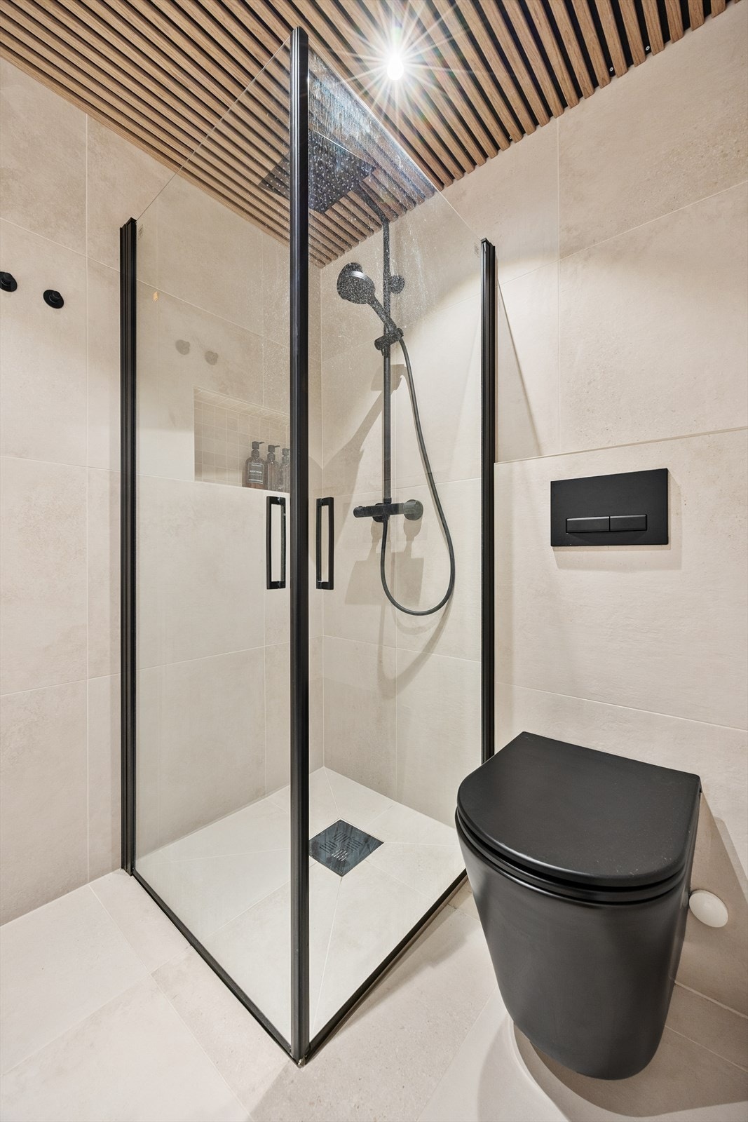 Dusjhjørne med nedsenket gulv, termostatbatteri og praktiske, innsvingbare dører. Galleribilde