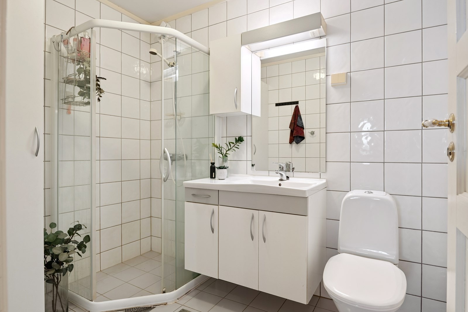 Badet er helfliset og fra byggeåret, innredet med dusjhjørne, servant med underskap og toalett. Baderomsvifte samt termostat på varmekabler er byttet i 2025. Galleribilde