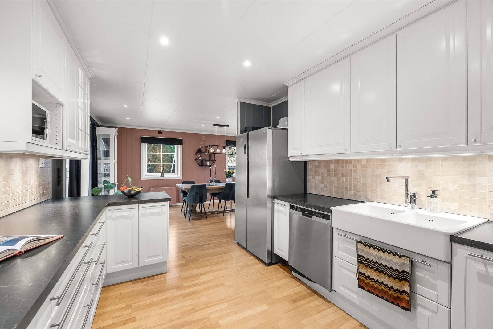 Kjøkkenet er både funksjonelt og sosialt utformet, med eikeparkett som flyter sømløst over i stuen. Galleribilde