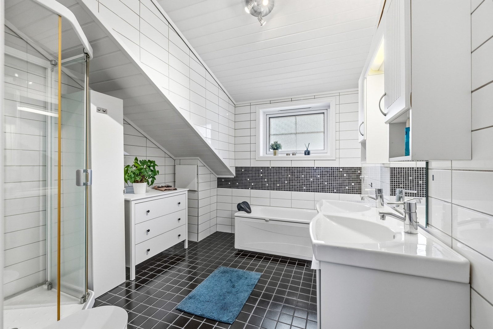 Badet i loftsetasjen byr på både et frittstående badekar og et separat dusjkabinett. Galleribilde