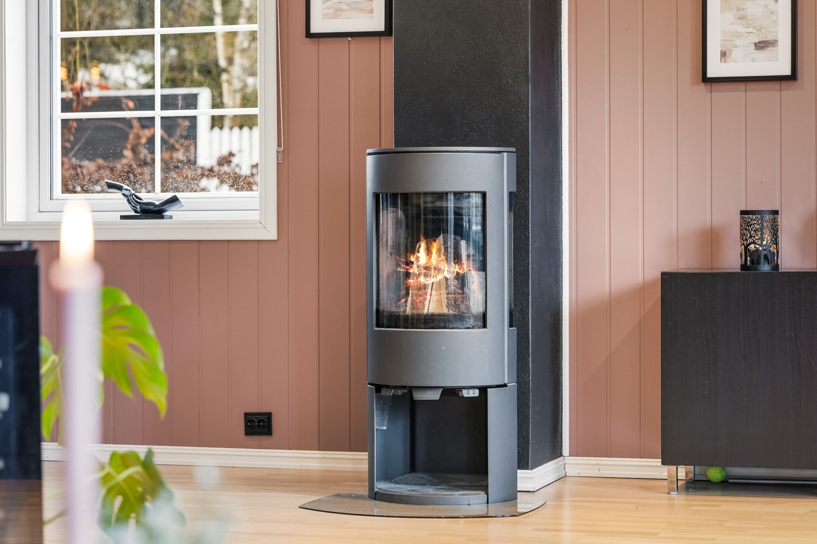 En moderne peisovn er sentralt plassert mellom stue- og spisesonen, og gir god varme på kjølige dager. Galleribilde