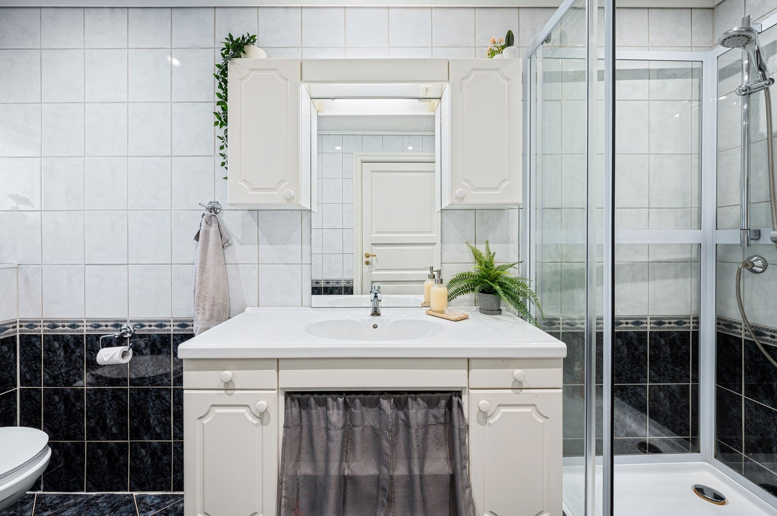 Inneholder vegghengt wc, dusjkabinett, benkeskap med nedfelt servant og speilfront. Galleribilde