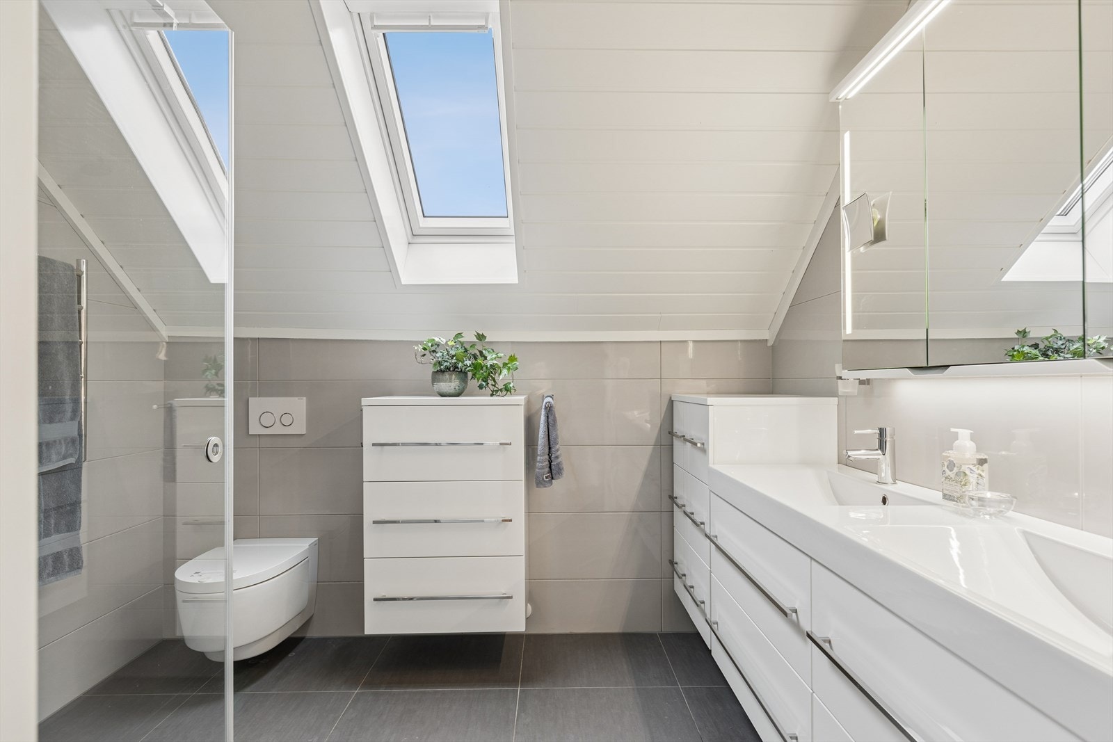 Bad med adkomst fra hovedsoverom er fra 2016. Badet er helfliset med elektriske varmekabler i gulv. Taket har panel. Rommet har innredning med 2 heldekkende servanter, eksklusivt veggmontert toalett med spylefunksjon samt dusjvegger/hjørne. Galleribilde