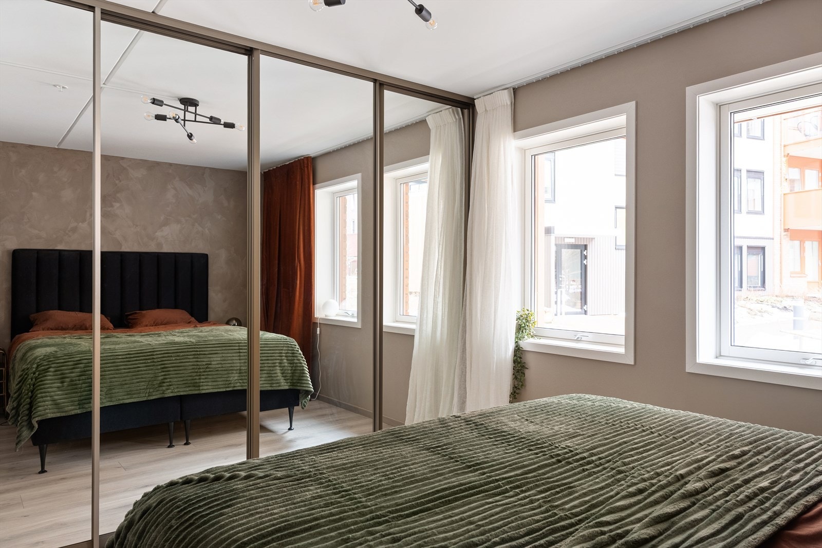 En spesialtilpasset garderobeløsning med speilfronter gir rikelig med oppbevaringsplass og en god romfølelse. Galleribilde