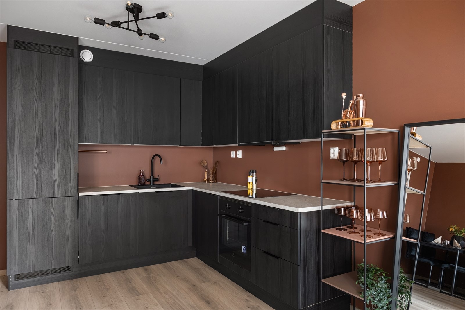 Leilighetens sosiale sone har et stilrent HTH-kjøkken fra 2024 med integrerte hvitevarer og god arbeidsplass. Galleribilde