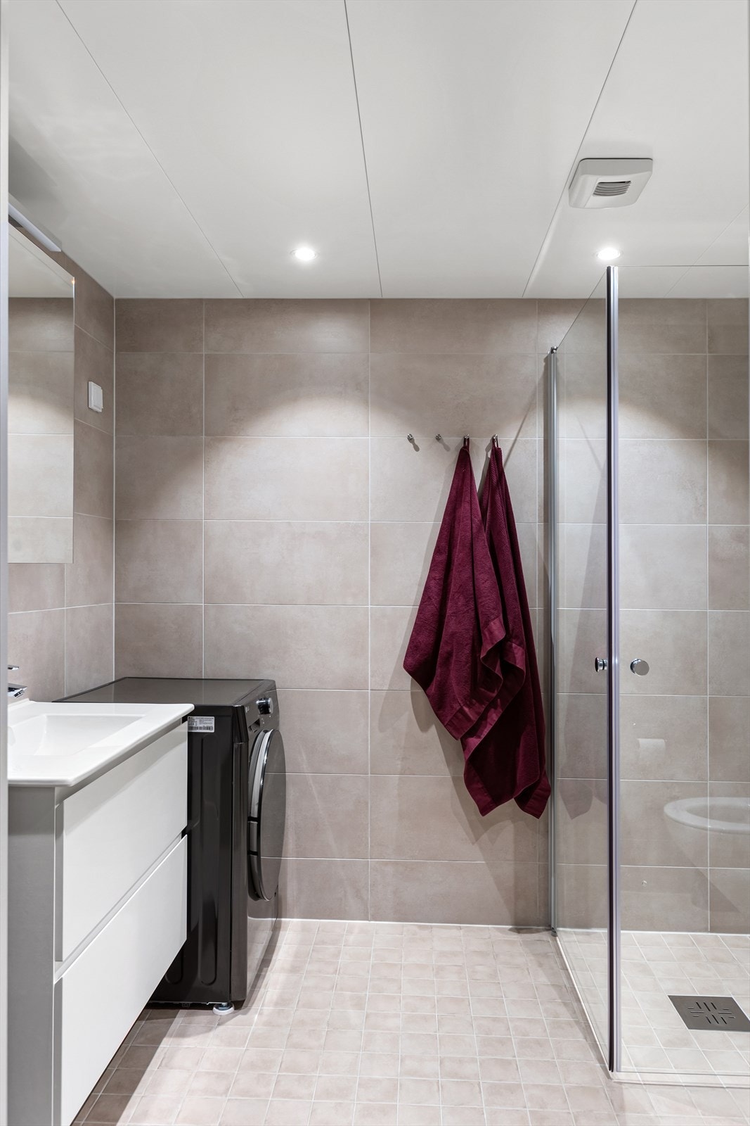 Moderne, flislagt bad fra 2024 med varmekabler i gulvet og opplegg for vaskemaskin. Galleribilde