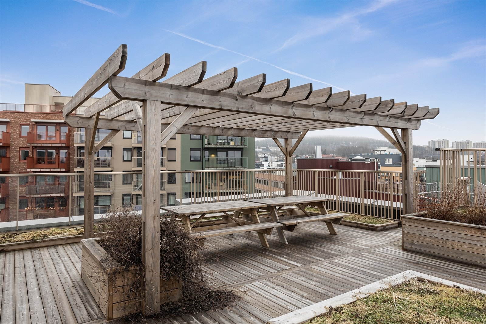 En pergola med sittebenker gir en lun og hyggelig sone på takterrassen. Galleribilde