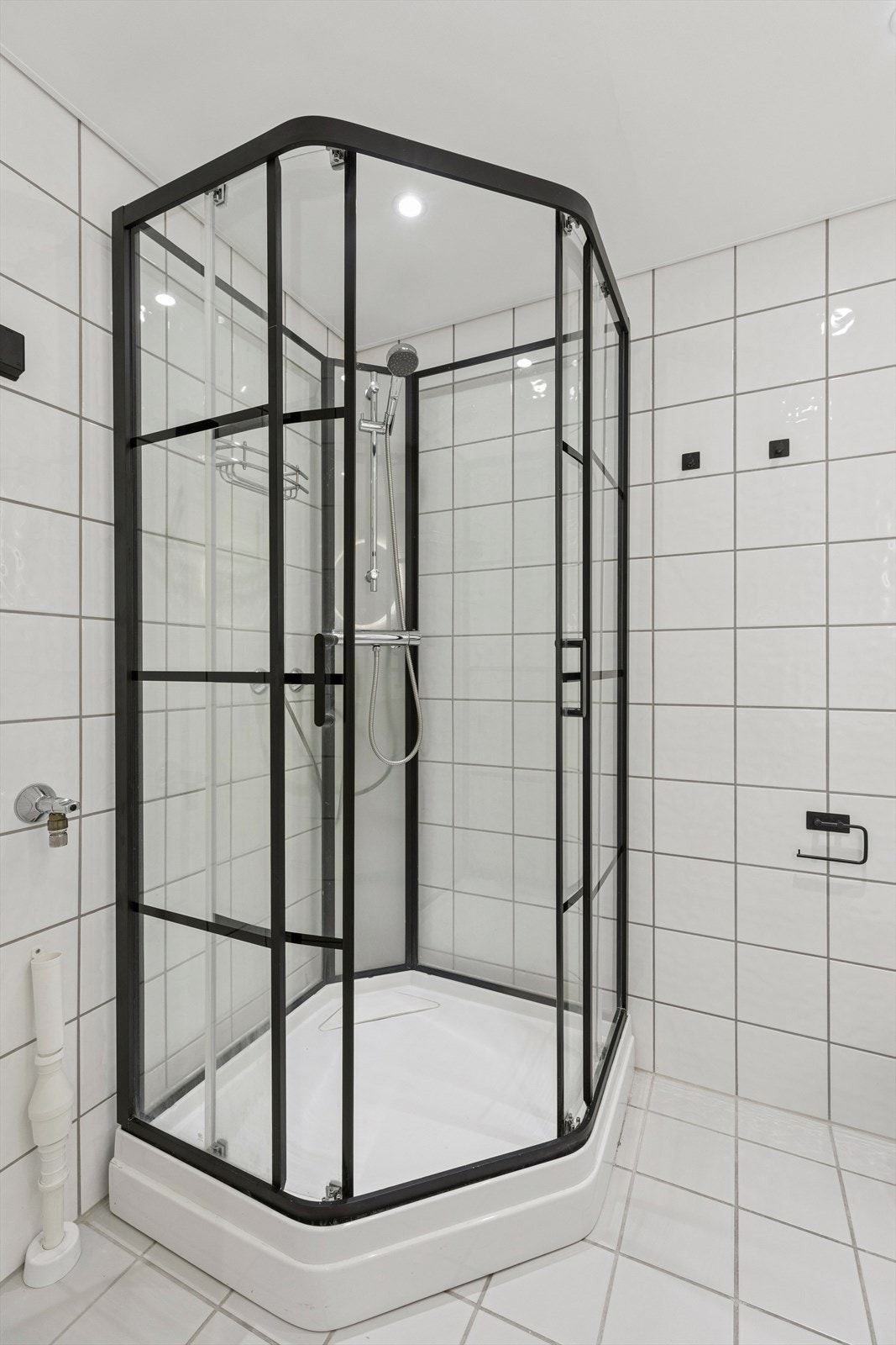 Pent dusjkabinett med sorte detaljer som gir en moderne og stilfull dusjløsning. Galleribilde