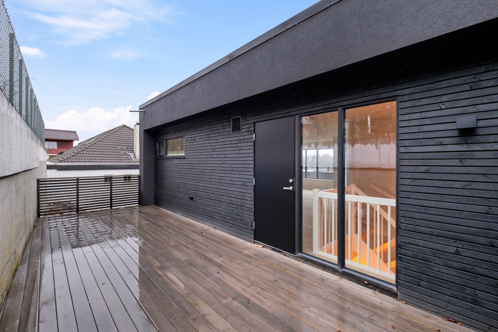 Treterrasse på terreng mot nord med utgang fra kjøkken. Galleribilde