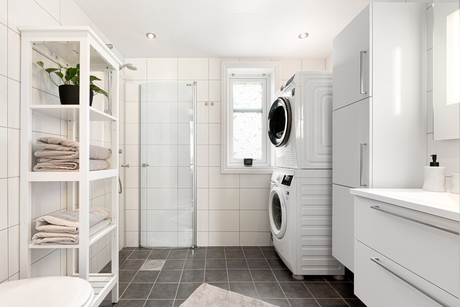 Et flisbelagt baderom med downlights i tak. Galleribilde