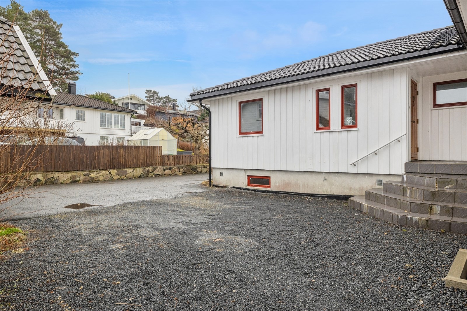 Biloppstillingsplass på gruslagt gårdsplass. Nabo har veirett. Felles asfaltert innkjørsel. Galleribilde