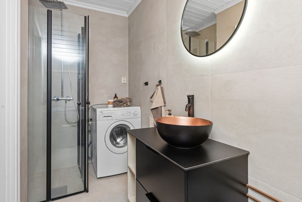 Rommet er utstyrt med dusj, baderomsinnredning med servant, opplegg for vaskemaskin, bereder, stoppekran og klosett. Galleribilde