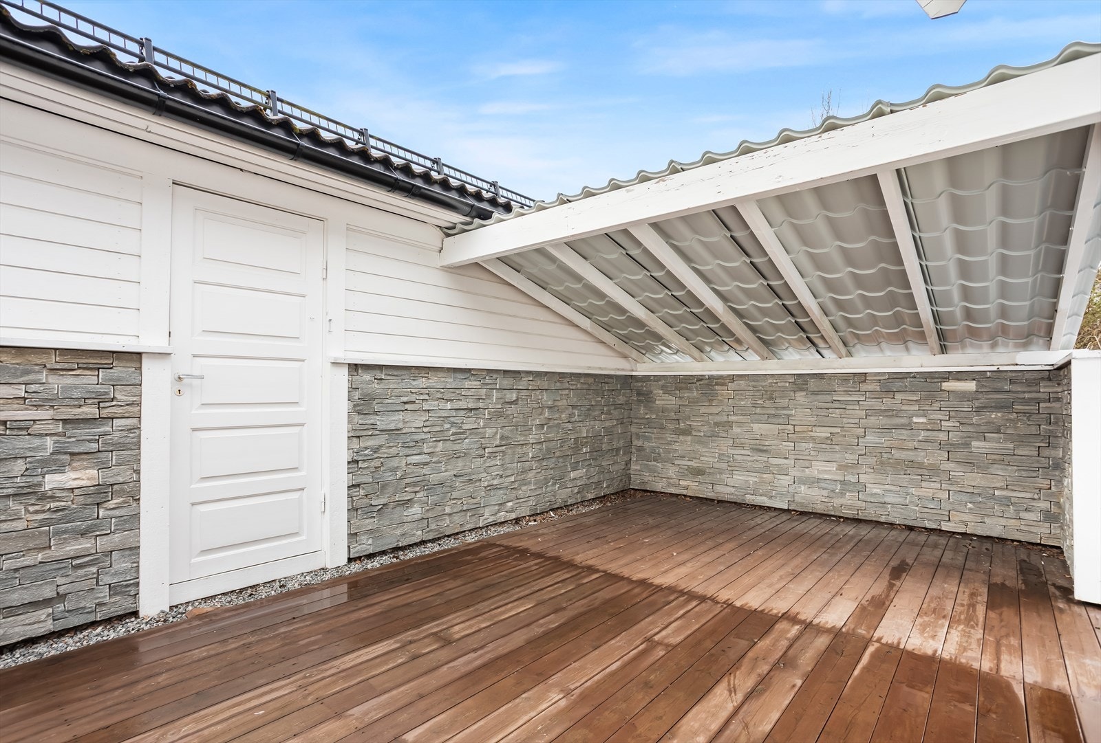 Praktisk, overbygd uteplass med adkomst til bod i bakkant av garasjen. Galleribilde