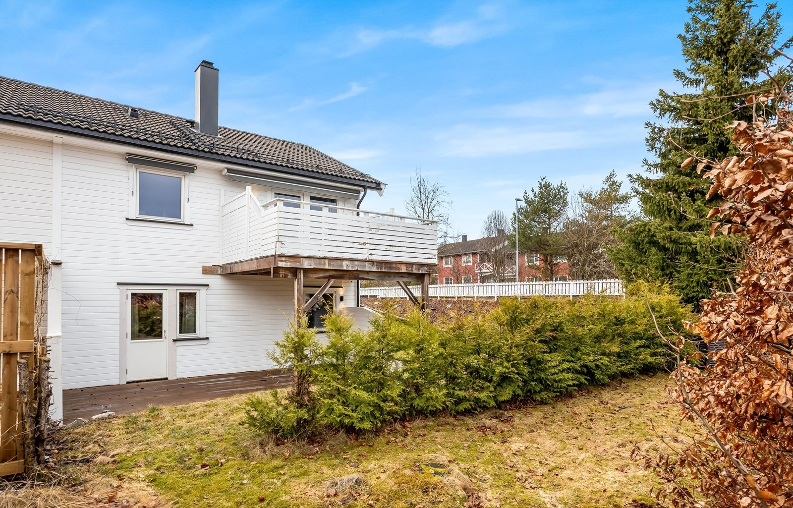 Boligen har liggende, hvitmalt kledning og tak tekket med sort takstein. Galleribilde