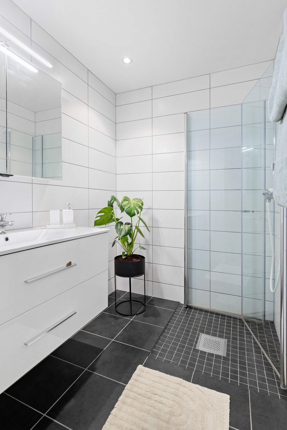 Lekkert flislagt bad komfortabel gulvvarme. Rommet er innredet med moderne innredning og dusjhjørne med innfellbare dører. Galleribilde