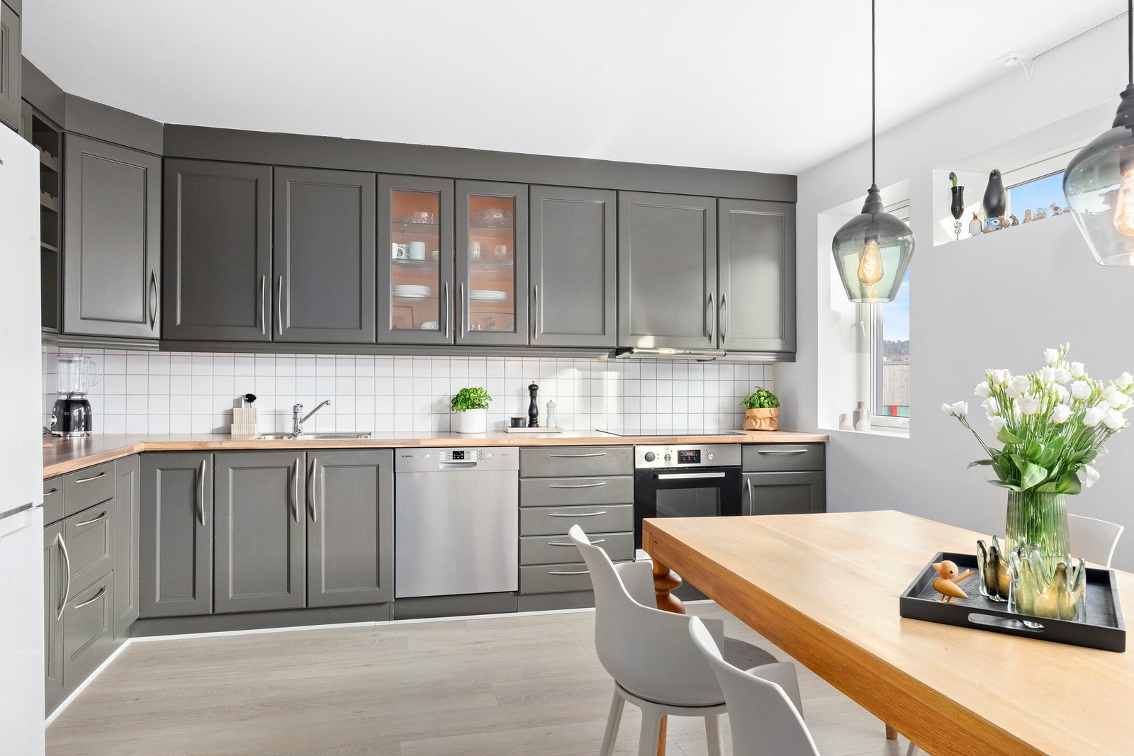 Pent kjøkken med lagring i over- og underskap og store arbeidsflater. Galleribilde