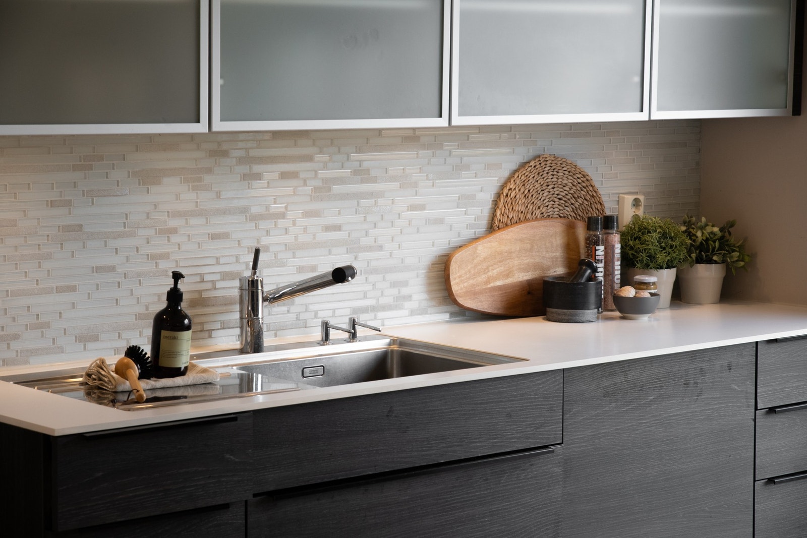 Mellom benkeplate og overskap er det fliser som gir et stilrent og lettstelt uttrykk, og benkebelysning sørger for gode arbeidsforhold. Galleribilde