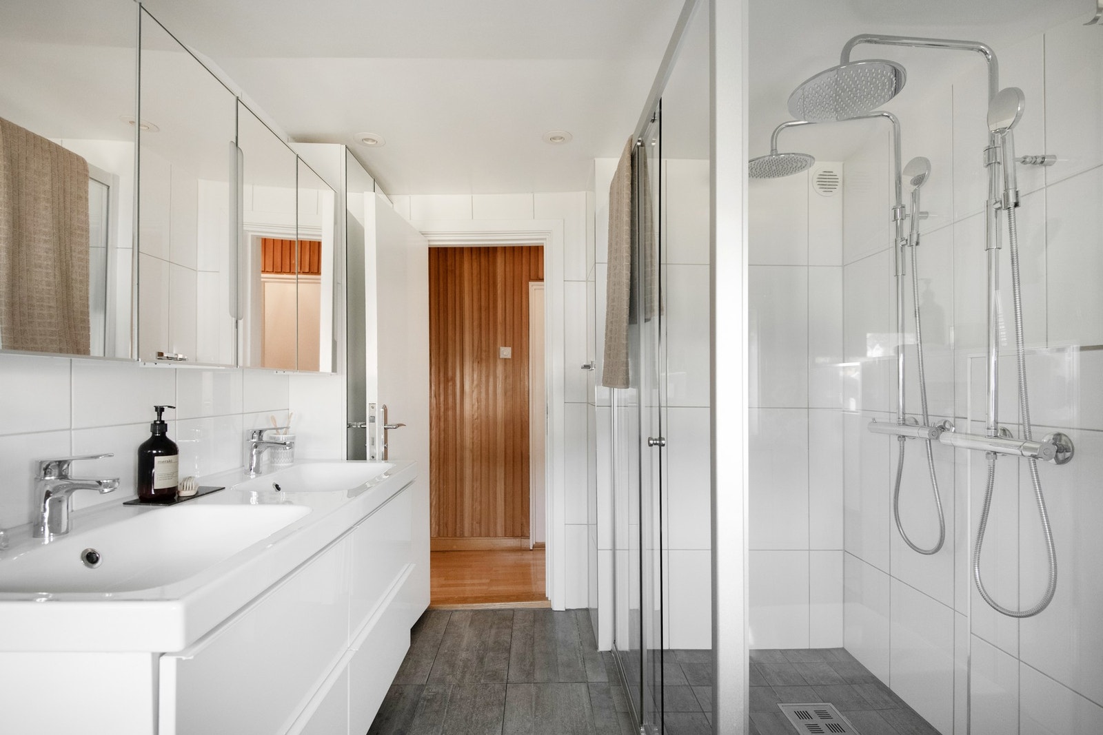 Delikat og romslig bad med flislagte overflater, gulvvarme og dusjløsning med to tak- og hånddusjer. Galleribilde