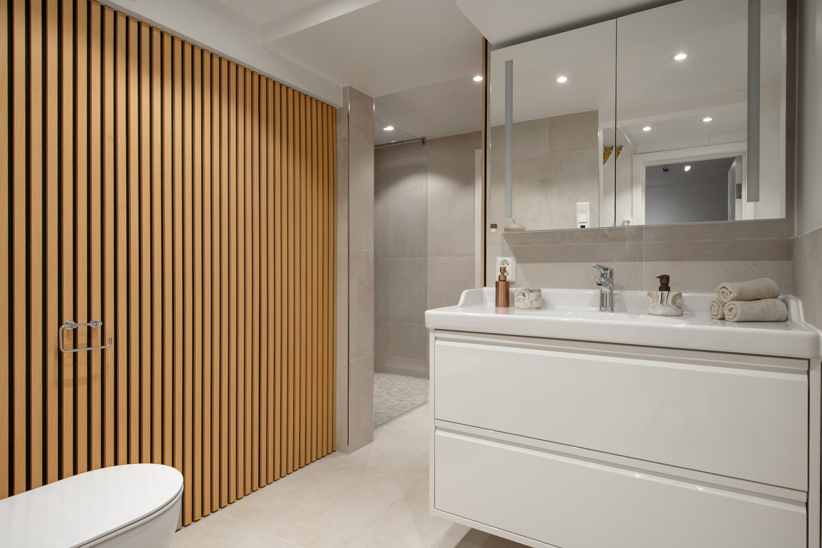 Badet har moderne innredning med dusj, servantskap og toalett. Galleribilde