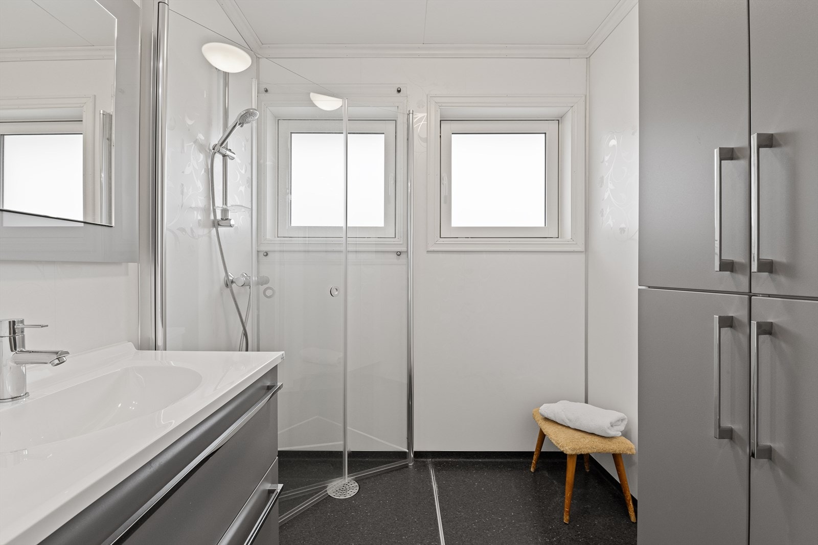 Lyst bad med dusjhjørne og servant med skuffer Galleribilde